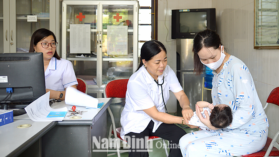 Cán bộ Trạm Y tế xã Nam Hùng kiểm tra sức khỏe cho trẻ em.