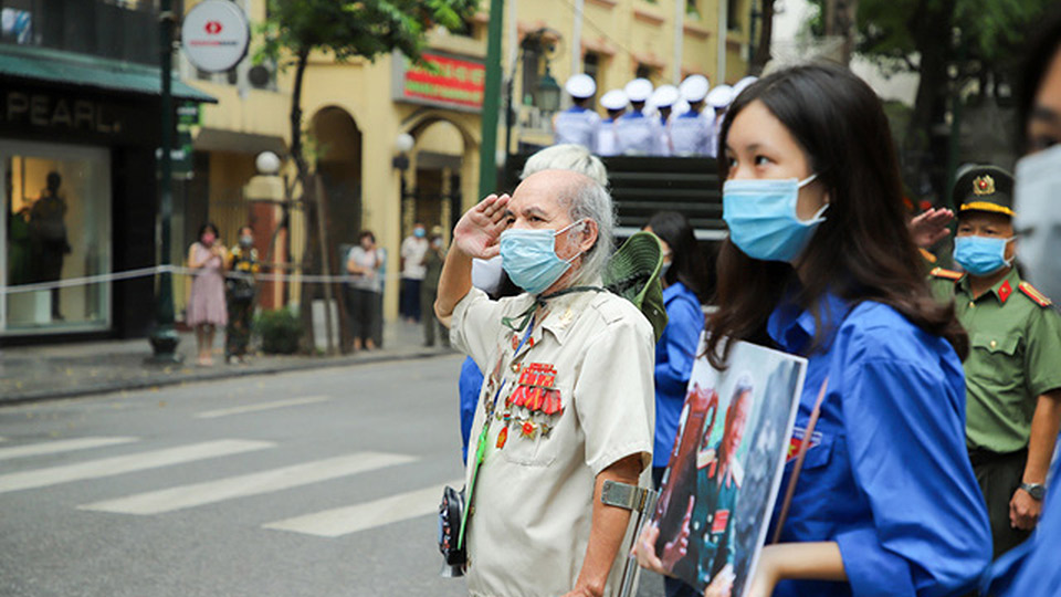 Người dân Thủ đô cầm di ảnh đứng hai bên tuyến đường đoàn xe tang đi qua để tiễn biệt nguyên Tổng Bí thư Lê Khả Phiêu. Ảnh: Nam Nguyễn
