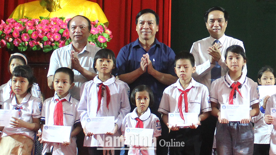 Đồng chí Trần Văn Chung, Phó Bí thư Thường trực Tỉnh ủy, Chủ tịch HĐND tỉnh trao học bổng cho các học sinh tiểu học vượt khó học giỏi.