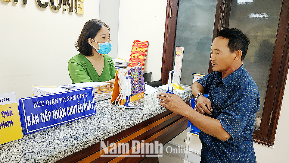 Nhân viên Bưu điện tỉnh tư vấn cho người dân về dịch vụ trả kết quả giải quyết thủ tục hành chính tận gia đình tại Trung tâm Phục vụ hành chính công tỉnh.