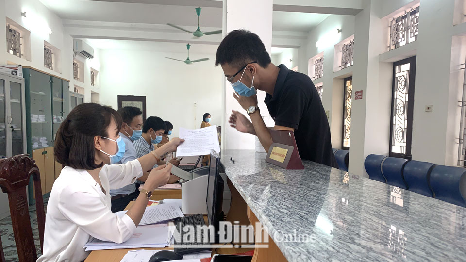 Cán bộ bộ phận “Một cửa” huyện Trực Ninh hướng dẫn người dân bổ sung thành phần hồ sơ cấp giấy chứng nhận quyền sử dụng đất.