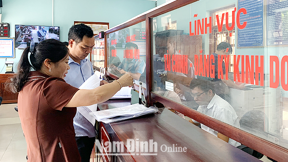 Cán bộ Trung tâm giao dịch hành chính "một cửa" huyện Giao Thủy giải quyết thủ tục hành chính cho người dân.