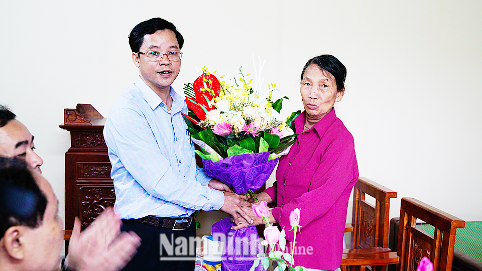 Đồng chí Nguyễn Đức Du, Phó Chủ tịch UBND huyện Ý Yên tặng hoa, chúc mừng gia đình bà Vàn.