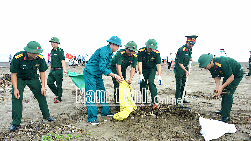 Cán bộ, chiến sĩ Ban CHQS huyện Nghĩa Hưng và lực lượng dân quân tự vệ tham gia dọn vệ sinh, làm sạch biển.