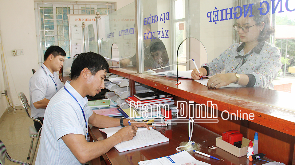 Cán bộ xã Nam Phong (thành phố Nam Định) giải quyết thủ tục hành chính cho nhân dân.