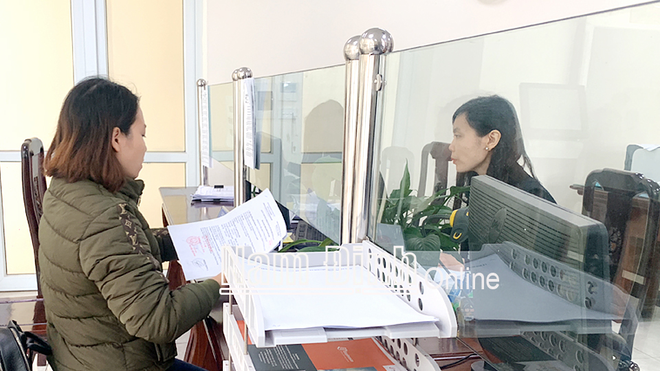 Cán bộ Chi cục Thuế khu vực Nam Định - Mỹ Lộc giải quyết thủ tục hành chính liên quan đến thu ngân sách Nhà nước với doanh nghiệp.