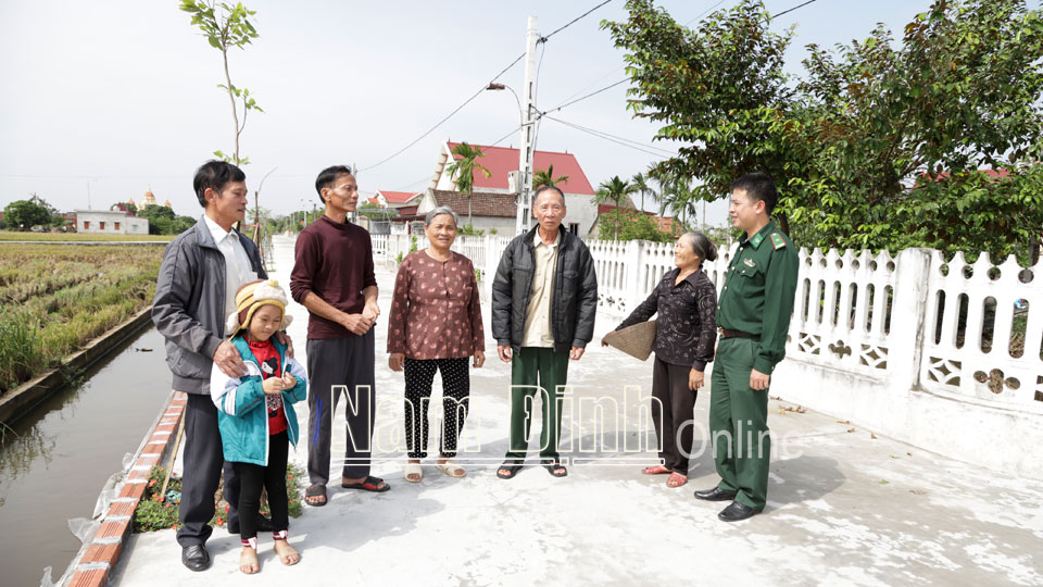 Cán bộ Đồn Biên phòng Ngọc Lâm trao đổi với bà con nhân dân khu dân cư kiểu mẫu xóm 2, xã Nghĩa Hải (Nghĩa Hưng).