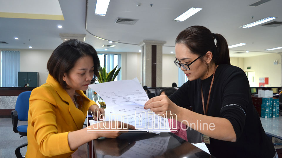 Cán bộ Kho bạc Nhà nước Nam Định hướng dẫn khách hàng hoàn thiện hồ sơ, chứng từ giao dịch.