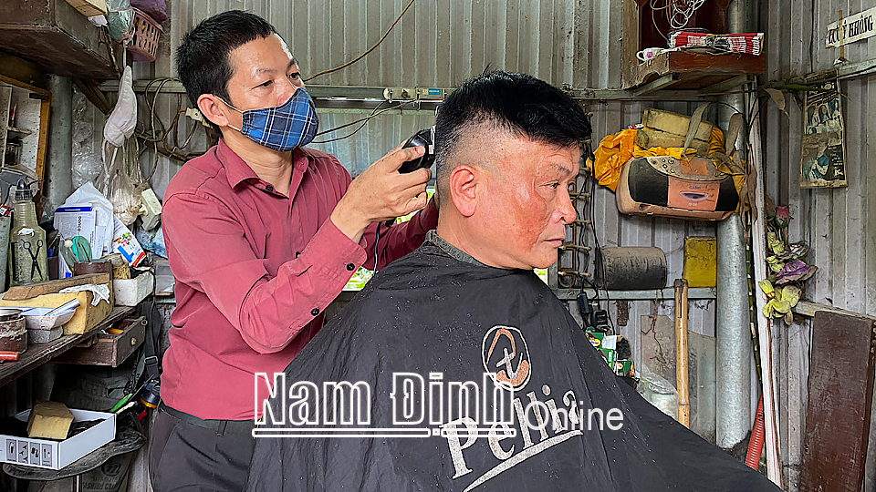 Anh Vũ Xuân Thuấn, ở xã Nam Phong (thành phố Nam Định) bị khuyết tật vận động nhưng có thu nhập ổn định nhờ nghề cắt tóc.