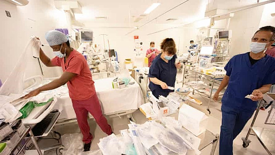 Nhân viên y tế tại một bệnh viện ở London, Anh, chuẩn bị giường cho người bệnh Covid-19 cần điều trị tích cực. (Ảnh: Guardian)