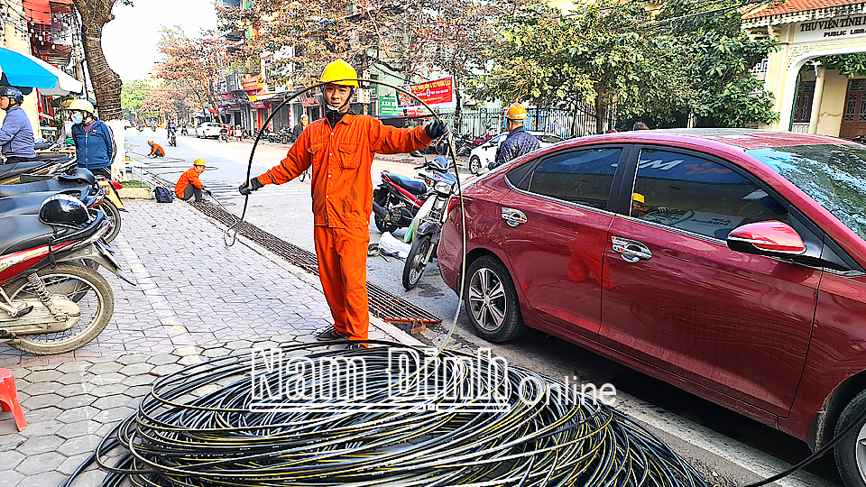 Công nhân Công ty Điện lực Nam Định triển khai lắp đặt tuyến đường điện trên phố Lê Hồng Phong (thành phố Nam Định).