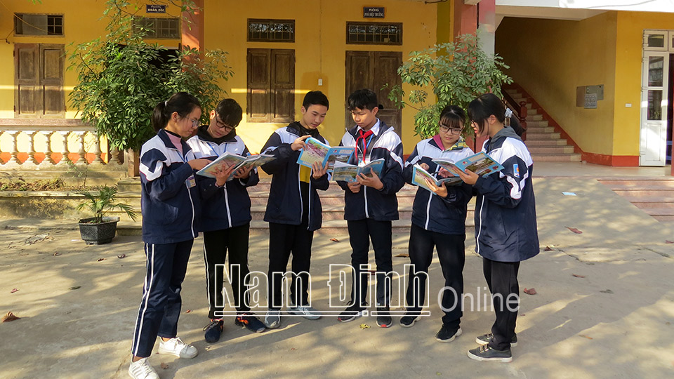 Các em học sinh Trường THCS Mỹ Xá (thành phố Nam Định) trao đổi bài trước giờ học.