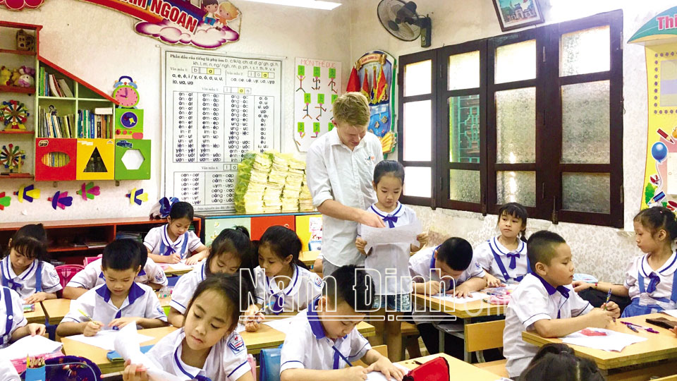 Cô và trò Trường THPT chuyên Lê Hồng Phong (ảnh trên); Một tiết học tiếng Anh với giáo viên nước ngoài của học sinh Trường Tiểu học Trần Quốc Toản, thành phố Nam Định (ảnh dưới).