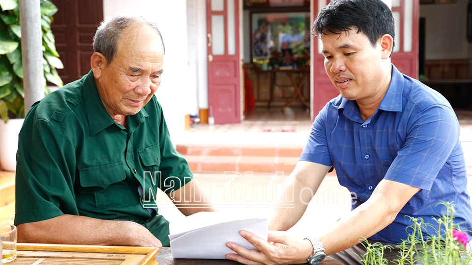 Bệnh binh Phạm Ngọc Cầu (bên trái) xã Bạch Long chia sẻ kinh nghiệm phát triển kinh tế với người dân địa phương.