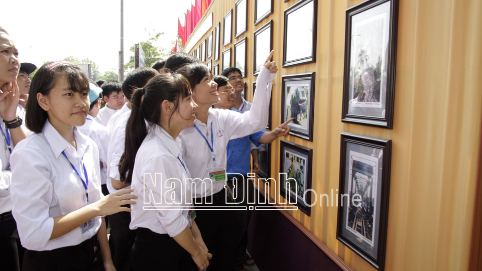 Học sinh Trường THPT A Hải Hậu (Hải Hậu) xem triển lãm ảnh tuyên truyền về an toàn giao thông.