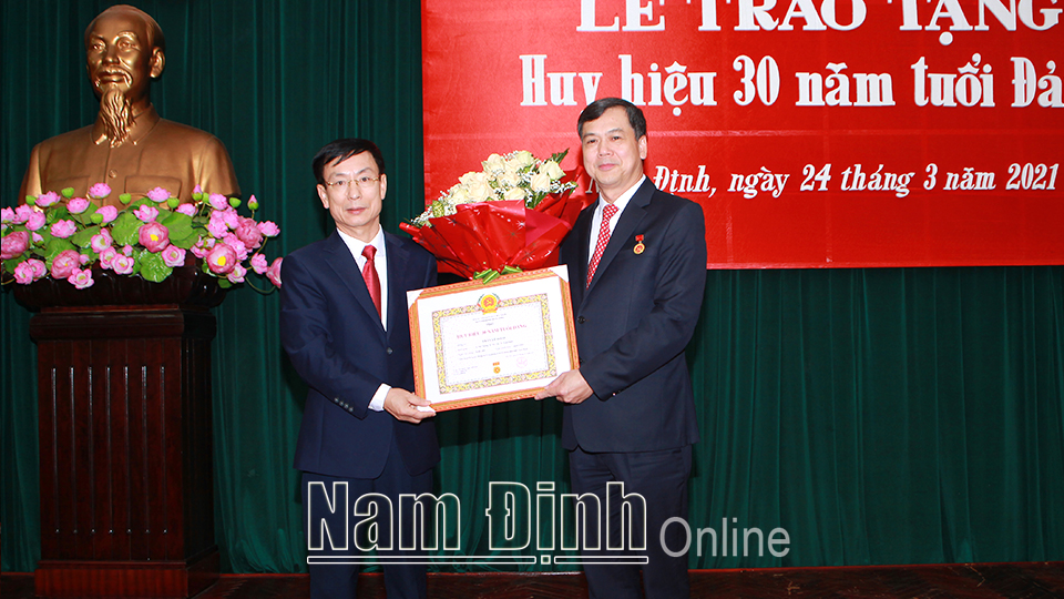 Đồng chí Phạm Đình Nghị, Phó Bí thư Tỉnh ủy, Chủ tịch UBND tỉnh trao tặng Huy hiệu 30 năm tuổi Đảng cho đồng chí Trần Lê Đoài.