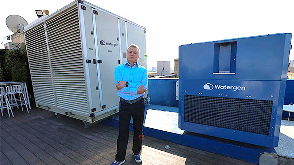 CEO Watergen Michael Mirilashvili đứng cạnh một cỗ máy chiết xuất nước từ không khí. (Ảnh: AFP).