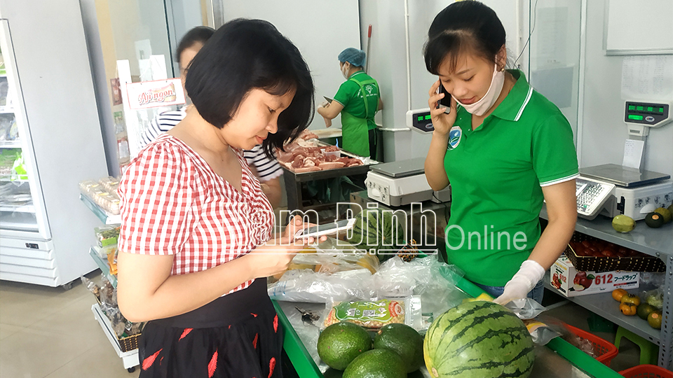Khách hàng sử dụng phần mềm truy xuất nguồn gốc thực phẩm khi mua hàng tại điểm bán hàng Việt tại thành phố Nam Định.  Bài và ảnh: Nguyễn Hương