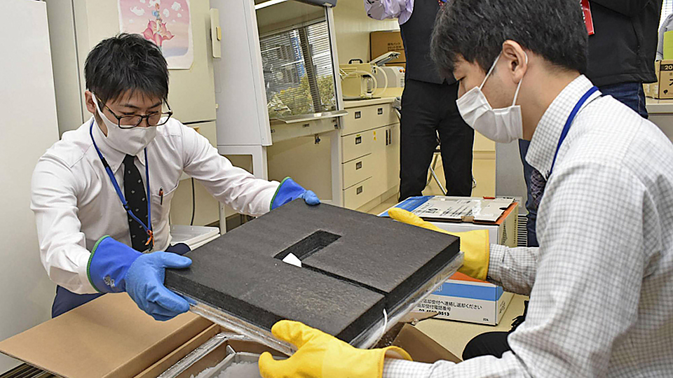 Kiểm tra các hộp chứa vaccine ngừa Covid-19 tại một địa điểm tiêm chủng ở Nagoya. Ảnh: Kyodo