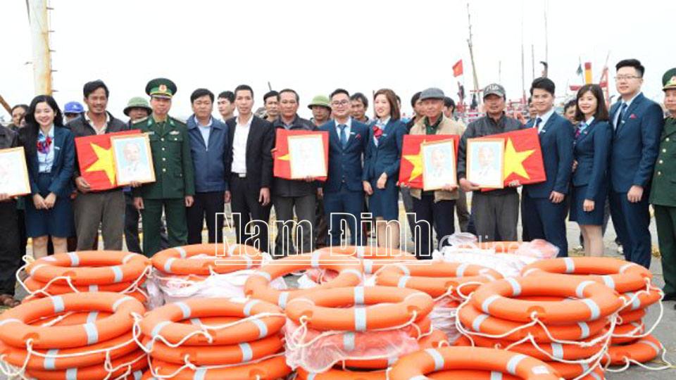 Lãnh đạo Bộ Chỉ huy BĐBP tỉnh và Ngân hàng VietinBank chi nhánh tỉnh Nam Định tổ chức trao tặng cờ Tổ quốc, ảnh Bác Hồ và phao cứu sinh cho các ngư dân đang neo đậu tàu thuyền tại Cảng Thịnh Long.