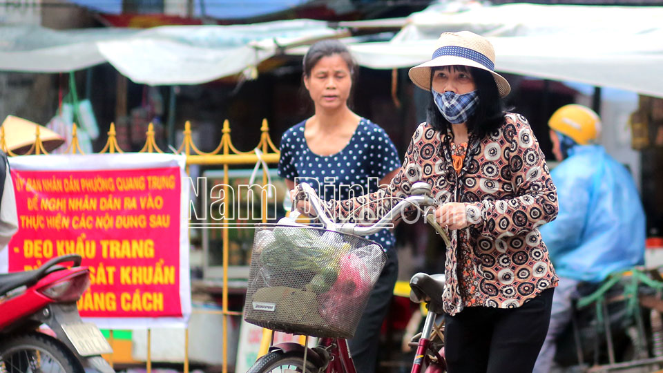 Ở chợ Diên Hồng (TP Nam Định) tuy có biển cảnh báo người dân đeo khẩu trang nhưng vẫn còn một số người chưa chấp hành.