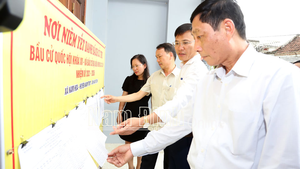 Đồng chí Nguyễn Văn Va, Ủy viên Ban TVTU, Trưởng Ban Tổ chức Tỉnh ủy và các thành viên UBBC tỉnh kiểm tra việc niêm yết danh sách cử tri tại điểm bầu cử thuộc xã Nam Hoa (Nam Trực).