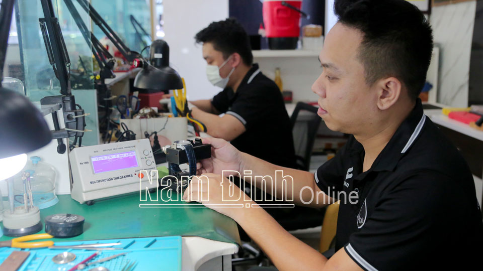 Anh Đặng Thế Lợi (thành phố Nam Định) đang kiểm tra, bảo dưỡng đồng hồ đeo tay của khách hàng.