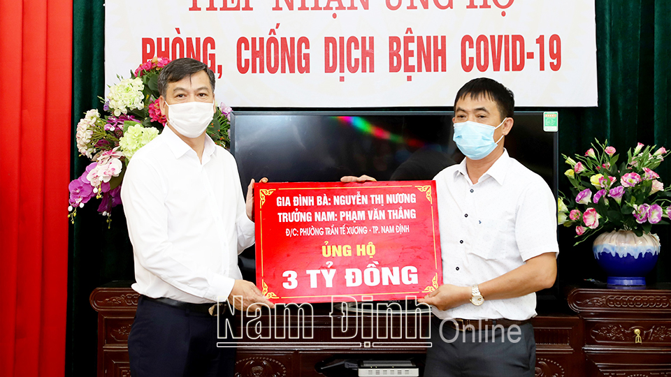 Đồng chí Phó Chủ tịch UBND tỉnh Trần Lê Đoài tiếp nhận quà ủng hộ của gia đình bà Nguyễn Thị Nương, phường Trần Tế Xương (thành phố Nam Định).