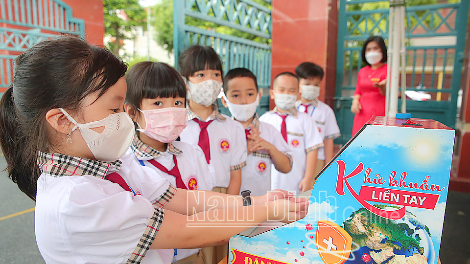 Học sinh trường Tiểu học Trần Nhân Tông (TP Nam Định) thực hiện rửa tay sát khuẩn trước khi vào trường.