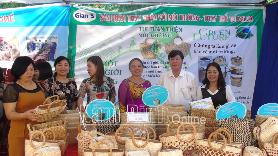 Chị Nguyễn Thị Hải (thứ 3 từ phải sang) giới thiệu các sản phẩm của cơ sở đan lát thủ công, kinh doanh hàng cói xuất khẩu Hùng Tiến, xã Nghĩa Lâm (Ảnh chụp trước ngày 27-4-2021).  Ảnh: Do cơ sở cung cấp