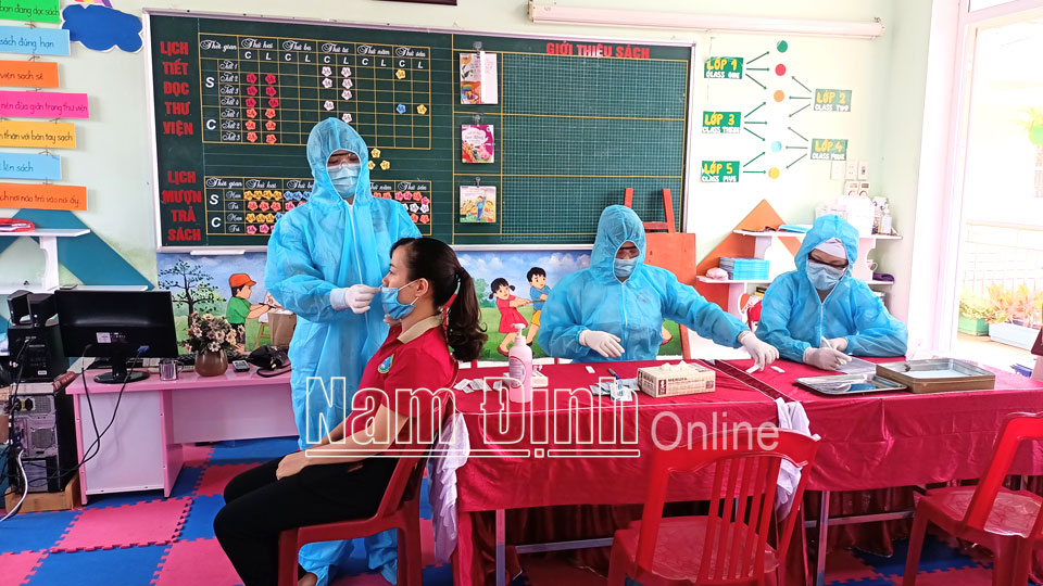 Test nhanh COVID-19 cho giáo viên, nhân viên Trường Tiểu học Chu Văn An (thành phố Nam Định).