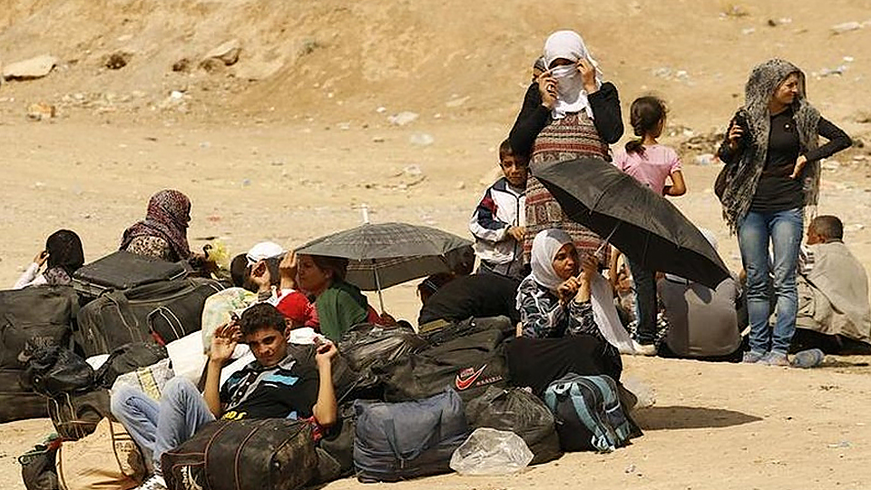 Người tị nạn Syria chuẩn bị vượt biên giới vào khu tự trị của người Kurd tại miền bắc Iraq, tháng 8/2013. (Ảnh: Reuters)