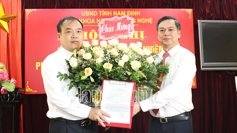 Đồng chí Trần Lê Đoài, TUV, Phó Chủ tịch UBND tỉnh trao Quyết định, tặng hoa chúc mừng đồng chí Vũ Xuân Trung.
