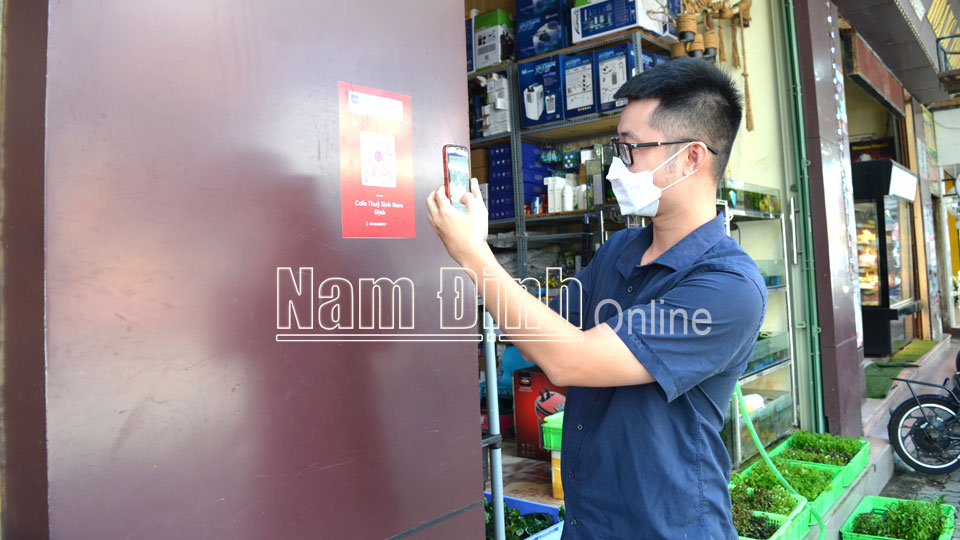 Người dân quét mã QR Code của Ngân hàng TMCP Quân đội Chi nhánh Nam Định để thanh toán mua sắm.