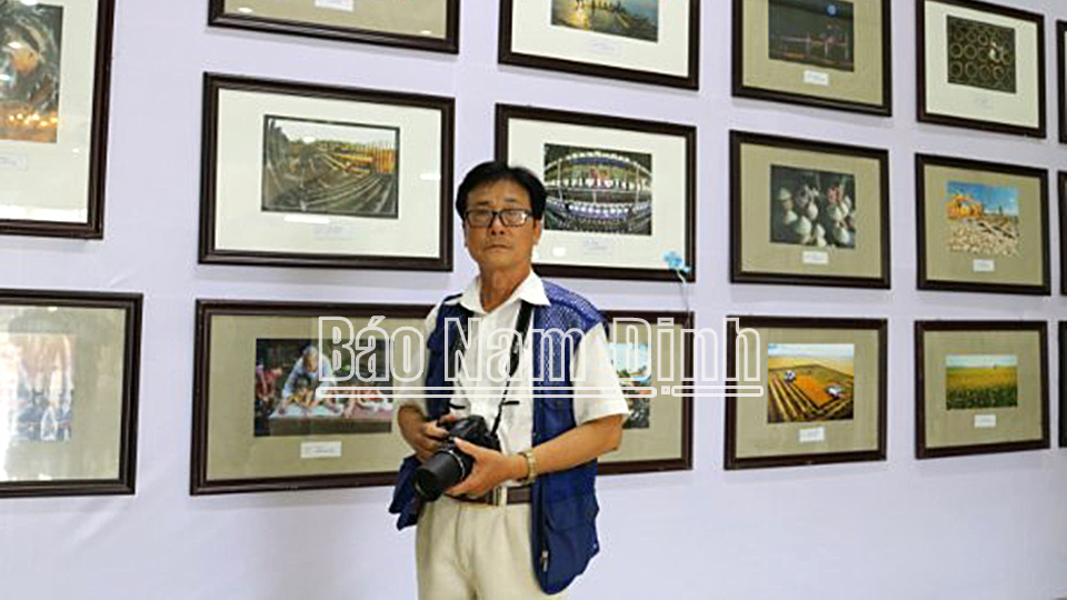 NSNA Chu Thế Vĩnh bên các tác phẩm của ông tại Liên hoan ảnh nghệ thuật Đồng bằng sông Hồng lần thứ XXI.