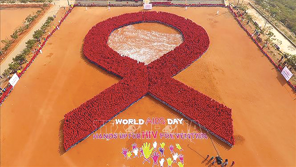 Xếp hình ruy băng đỏ nhân Ngày Thế giới phòng, chống HIV/AIDS tại Bhubaneswar, Ấn Độ.  Ảnh: AFP/TTXVN
