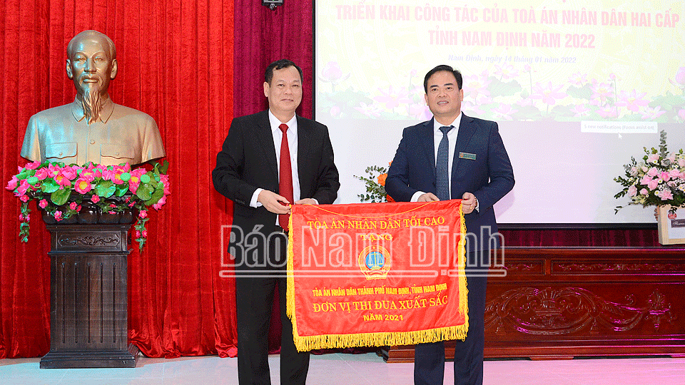 Đồng chí Lê Quốc Chỉnh, Phó Bí thư Thường trực Tỉnh ủy, Chủ tịch HĐND tỉnh, Trưởng đoàn Đoàn đại biểu Quốc hội tỉnh trao Cờ thi đua xuất sắc của TAND tối cao năm 2021 cho TAND thành phố Nam Định.