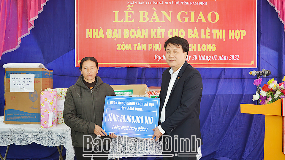 Đồng chí Trần Duy Hưng, Giám đốc Ngân hàng CSXH Chi nhánh tỉnh tặng tiền ủng hộ xây dựng nhà Đại Đoàn kết cho chị Lê Thị Hợp ở xóm Tân Phú, xã Bạch Long (Giao Thuỷ). 