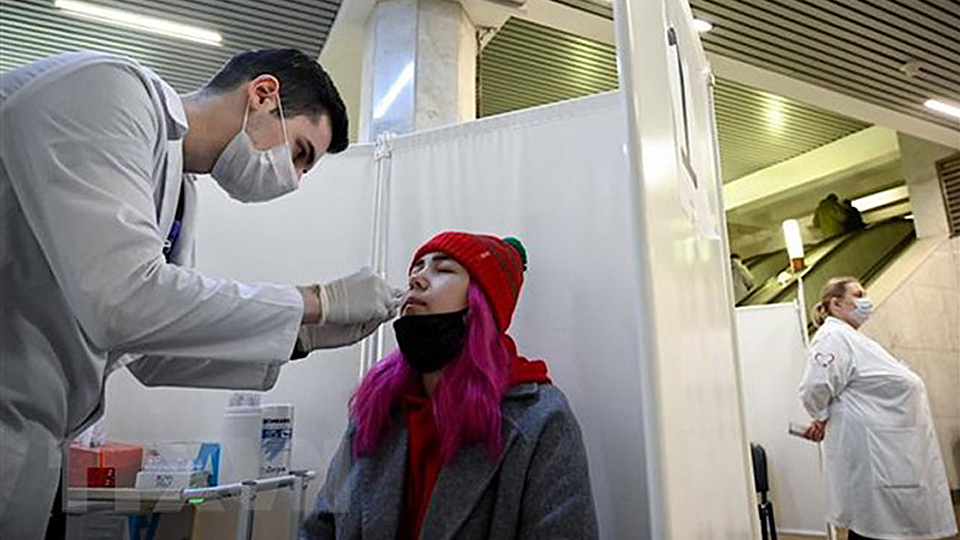 Nhân viên y tế lấy mẫu xét nghiệm COVID-19 cho người dân tại Moskva, Nga ngày 11/10/2021. (Ảnh: AFP/TTXVN)