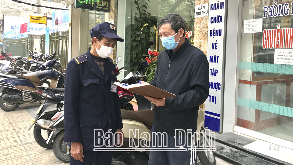 Ông Phạm Văn Tâm (bên phải), Bí thư chi bộ khu dân cư An Phong, phường Quang Trung (thành phố Nam Định) tuyên truyền phòng chống dịch Covid-19 đến các hộ kinh doanh trên địa bàn.