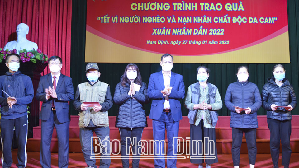 Đồng chí Phó Bí thư Thường trực Tỉnh uỷ và đại diện nhà tài trợ trao tặng các suất quà cho đại diện các gia đình người nghèo và nạn nhân chất độc da cam trên địa bàn thành phố Nam Định.