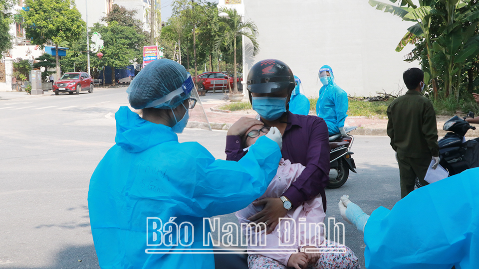 Lấy mẫu xét nghiệm sàng lọc cho người dân ở phường Lộc Hạ (thành phố Nam Định).