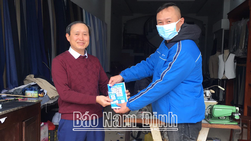 Nhân viên VNPT Nam Định trao mã QR cho điểm chấp nhận thanh toán Mobile Money trên địa bàn huyện Hải Hậu.