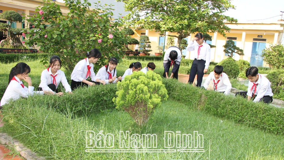 Học sinh Trường THCS Bình Hoà (Giao Thuỷ) chăm sóc vườn cây trong khuôn viên trường.