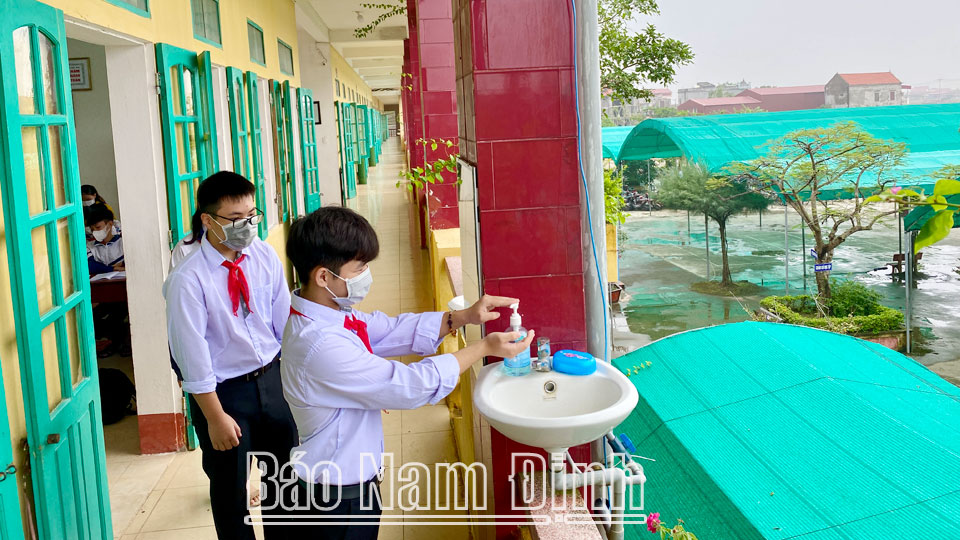Học sinh Trường THCS Hải Lý (Hải Hậu) sát khuẩn tay phòng dịch COVID-19 trước khi vào lớp học.