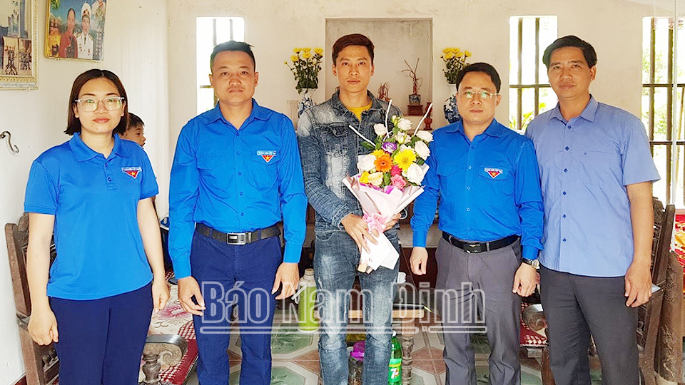 Cấp ủy, chính quyền thị trấn Thịnh Long và Đoàn Thanh niên địa phương thăm, tặng hoa biểu dương anh Nguyễn Văn Chính. Ảnh: Do cơ sở cung cấp