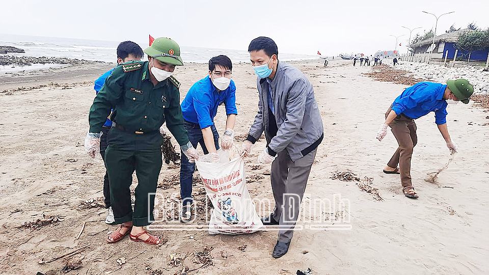 Đồng chí Nguyễn Hồng Lâm (ở giữa) tham gia dọn dẹp vệ sinh môi trường biển.