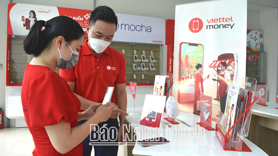 Cán bộ Viettel Nam Định hướng dẫn người dân quét mã QRCode thanh toán cước viễn thông bằng ứng dụng Viettel Money trên điện thoại thông minh.