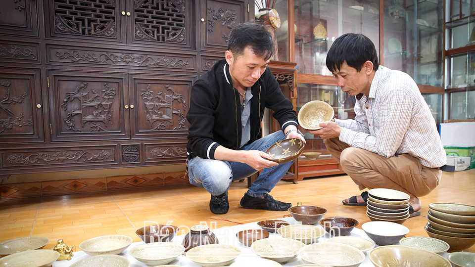 Anh Triệu Thanh Sơn (bên trái), thành phố Nam Định trao đổi kiến thức đồ gốm, sứ cổ cho người mới sưu tầm.