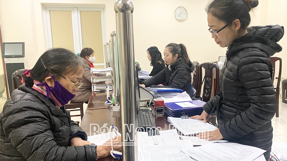 Cán bộ Chi cục Thuế khu vực thành phố Nam Định - Mỹ Lộc hướng dẫn người nộp thuế làm thủ tục nghĩa vụ thuế.